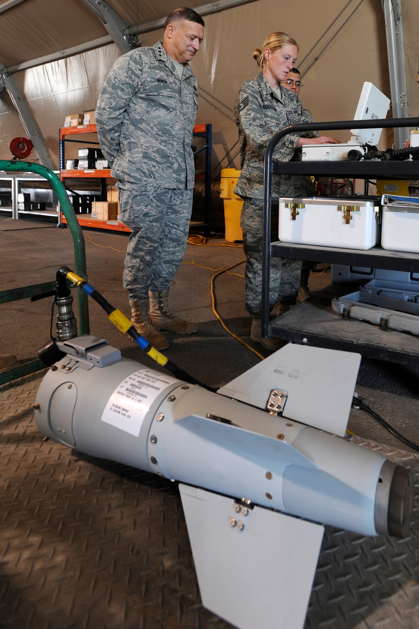 Staff Sgt. Melissa Roberston, a Munitions Technician with the 379th Expeditionary Maintenance Squadron, shows Lt. General Gary North, Commander U.S. Air Forces Central, the CMBRE System, Jan. 31, 2009, in an undisclosed location in Southwest Asia.  The CMBRE System tests the munitions tail kit for reliability and updates the data systems on the munitions.  General North is based at Shaw Air Force Base, S.C. and Airman Simmons is native to Hartland, Co. and is deployed from Dyess Air Force Base, Texas in support of Operations Iraqi and Enduring Freedom and Combined Joint Task Force - Horn of Africa.(U.S. Air Force Photo by Staff Sgt. Joshua Garcia/released)