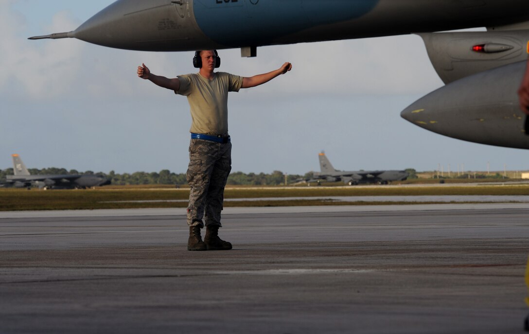 Amn First Class Jared Gunn, crew chief marshals in an F-16 Fighting Falcon, 18th Aggressor Squadron, Eielson Air Force Base, Alaska, after landing Jan. 31 at Andersen AFB, Guam for exercise Cope North 09-1 from 2-13 Feb. Japan Air Self Defense Force F-2s  from the 6th Squadron, Tsuiki Air Base and E-2Cs from the 601st Squadron, Misawa Air Base will join forward deployed USAF  F-16 Fighting Falcons from the 18th Aggressor Squadron, Eielson AFB Alaska, B-52 Stratofortress' currently deployed to Andersen AFB, Guam from the 23rd Expeditionary Bomb Squadron, and Navy EA-6B from VAQ-136 Carrier Air Wing Five, Atsugi, Japan will participate in this year's exercise with a focus on interoperability. Airman Gunn is assigned to the 354th Aircraft Maintenance Squadron, Eielson AFB Alaska. (U.S. Air Force photo/ Master Sgt. Kevin J. Gruenwald) released      