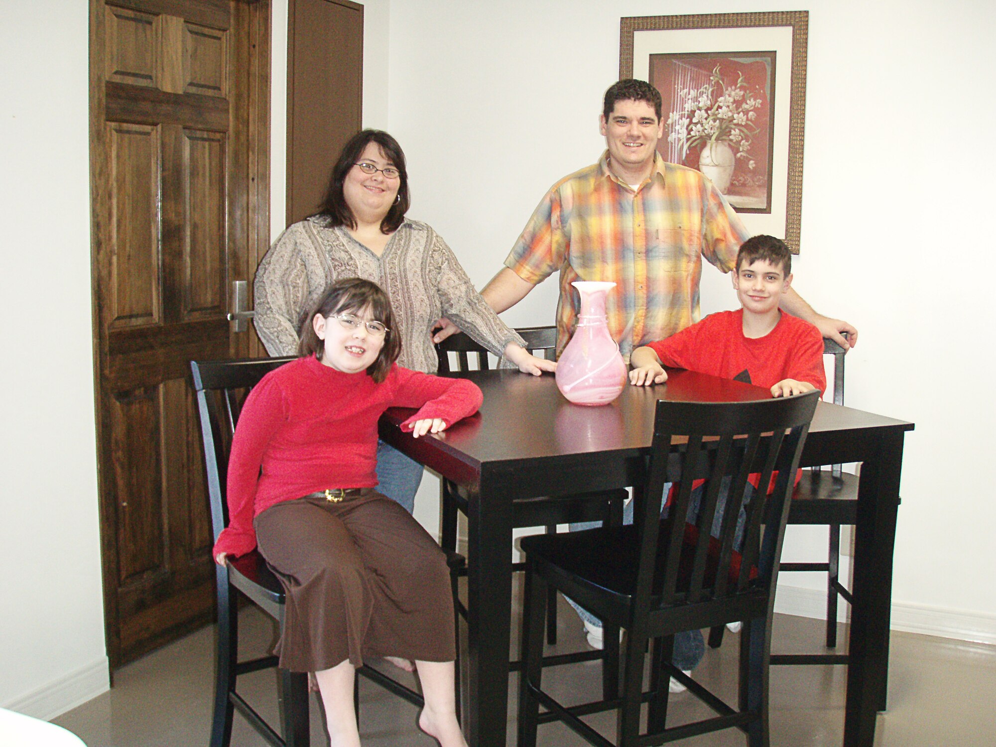 MISAWA AIR BASE, Japan -- Staff Sgt. Donny Ryals, 35th Maintenance Squadron aircraft fuel system craftsman, poses with his wife, Tammy, and their daughter, Kayla, 8, and son, Dylan, 10, at the dining room table they purchased with part of the $1,000 he won in a drawing during the Air Force Clubs membership drive. (Courtesy photo)      