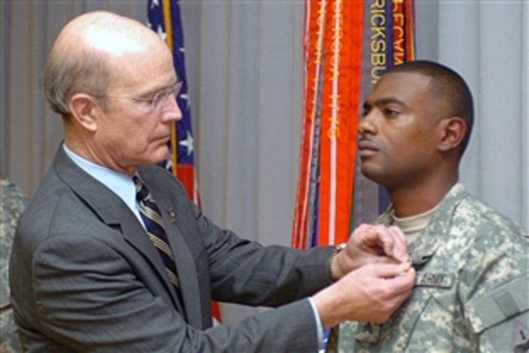 U.S. Army Secretary Pete Geren presents the Purple Heart to Sgt. Justin Smith, a team leader for 1st Platoon, Company B, 70th Engineer Battalion, during an awards ceremony at Walter Reed Army Medical Center, Jan. 30, 2009.  This marks the second time Smith has been awarded the Purple Heart.  
