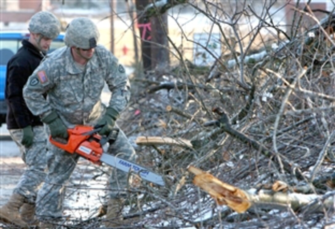 U.S. Army Sgt. Thomas Kelly and a fellow soldier form clear branches lying across the streets of Mayfield, Ky., following an ice storm, Jan. 30, 2009. The soldiers are assigned to Company A, 149th Brigade Support Battalion.