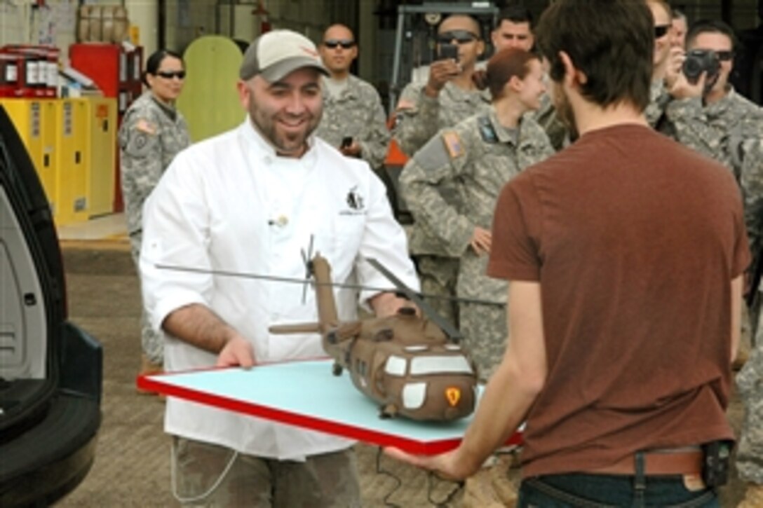 Jeffrey "Duff" Goldman and Geoffrey Manthorne, stars of the Food Network show "Ace of Cakes," move a cake shaped and decorated to look like a UH-60 Blackhawk, to the Wheeler Army Airfield location for the "Hero" shot, Jan. 29, 2009. The "Ace of Cakes" crew videotaped their season finale on Schofield Barracks, Hawaii.
