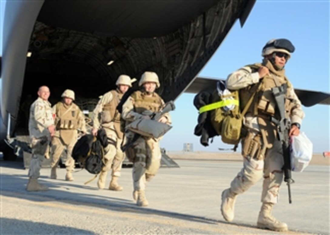 U.S. Navy Seabees assigned to Naval Mobile Construction Battalion 7 exit an Air Force C-17 Globemaster III aircraft after arriving at a forward operating base in the Helmand province of Afghanistan on Jan. 25, 2009.  Naval Mobile Construction Battalion 7 is deployed to Afghanistan to provide contingency construction support to alliance forces supporting NATO International Security Assistance Forces.  