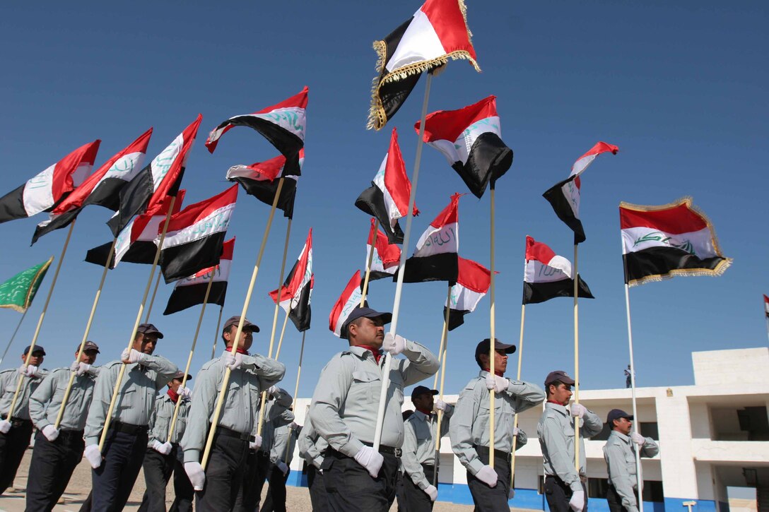 Students march bye carrying their nations colors at the start of the ceremony. The ceremony celebrated the graduation of 328 of Iraq's finest. (Official Photo by Sgt. Dorian Gardner)