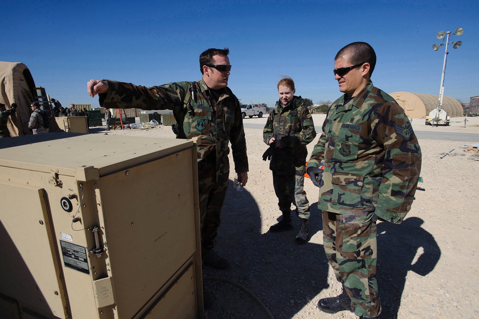 BROOKS CITY-BASE, Texas --Tech. Sgt. William Meyers, U.S. Air Force School of Aerospace Medicine, Expeditionary Medical Support Course instructor, goes through the set up of a portable environmental control unit with Staff Sgt. Callie Moore, 374th Medical Support Squadron medical logistics technician and Staff Sgt. Leonardo Mora, 374 MDSS Biomedical equipment technician, during set up of an EMEDS portable hospital package. The tent build up phase, during the first day of EMEDS training allows 374th Medical Group personnel the skills required to deploy a basic EMEDS package within 24 hours of arriving at a deployed location. Both sergeants are assigned to Yokota Air Base, Japan. (U.S. Air Force photo/Steve Thurow)