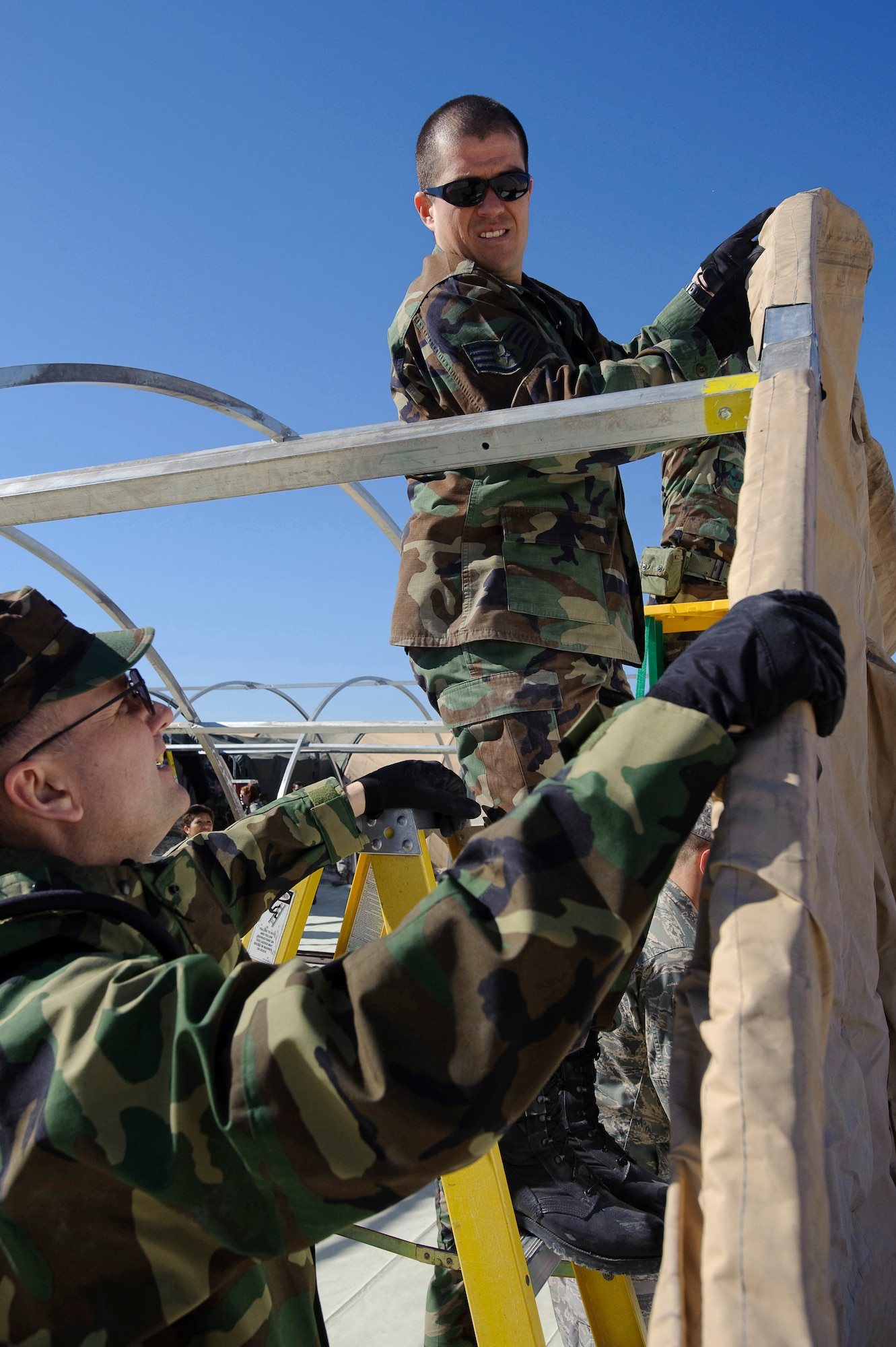 Col. Tim Robinette (foreground), commander of the 374th Medical Group , and Staff Sgt. Leonardo Mora, Biomedical Equipment Technician with the 374th Medical Support Squadron, assemble the wall of a medical care tent during Expeditionary Medical Support Course (EMEDS) training with the U.S. Air Force School of Aerospace Medicine, Brooks City-Base, Texas Feb. 2. The tent build-up phase, during the first day of EMEDS gives 374th Medical Group personnel the skills required to deploy a basic EMEDS package within 24 hours of arriving at a deployed location. (U.S. Air Force photo/Steve Thurow)