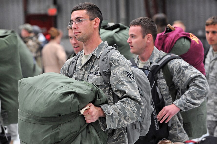 Returning Ellsworth Airmen grab their luggage as they are greeted by friends and family here, January 31. Approximately 300 Airmen, serving in various roles, return after supporting Operations Iraqi and Enduring Freedom. (U.S. Air Force photo/Senior Airman Marc I. Lane)