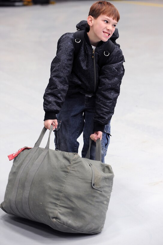 Dillon Ellis, 11, helps his dad, Staff Sgt. Marcus Ellis, 28th Munitions Squadron munitions systems specialist, by dragging his bag here, January 31. Sergeant Ellis was deployed in support of Operations Iraqi and Enduring Freedom. (U.S. Air Force photo/Senior Airman Marc I. Lane)