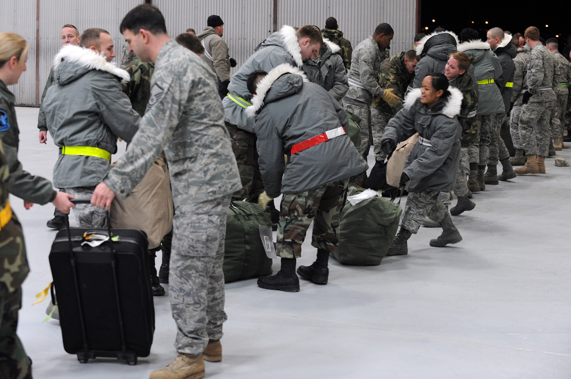 A group of Ellsworth Airmen unload bags here, January 31. The Airmen volunteered to help unload the bags for those returning from their deployments. (U.S. Air Force photo/Senior Airman Marc I. Lane)