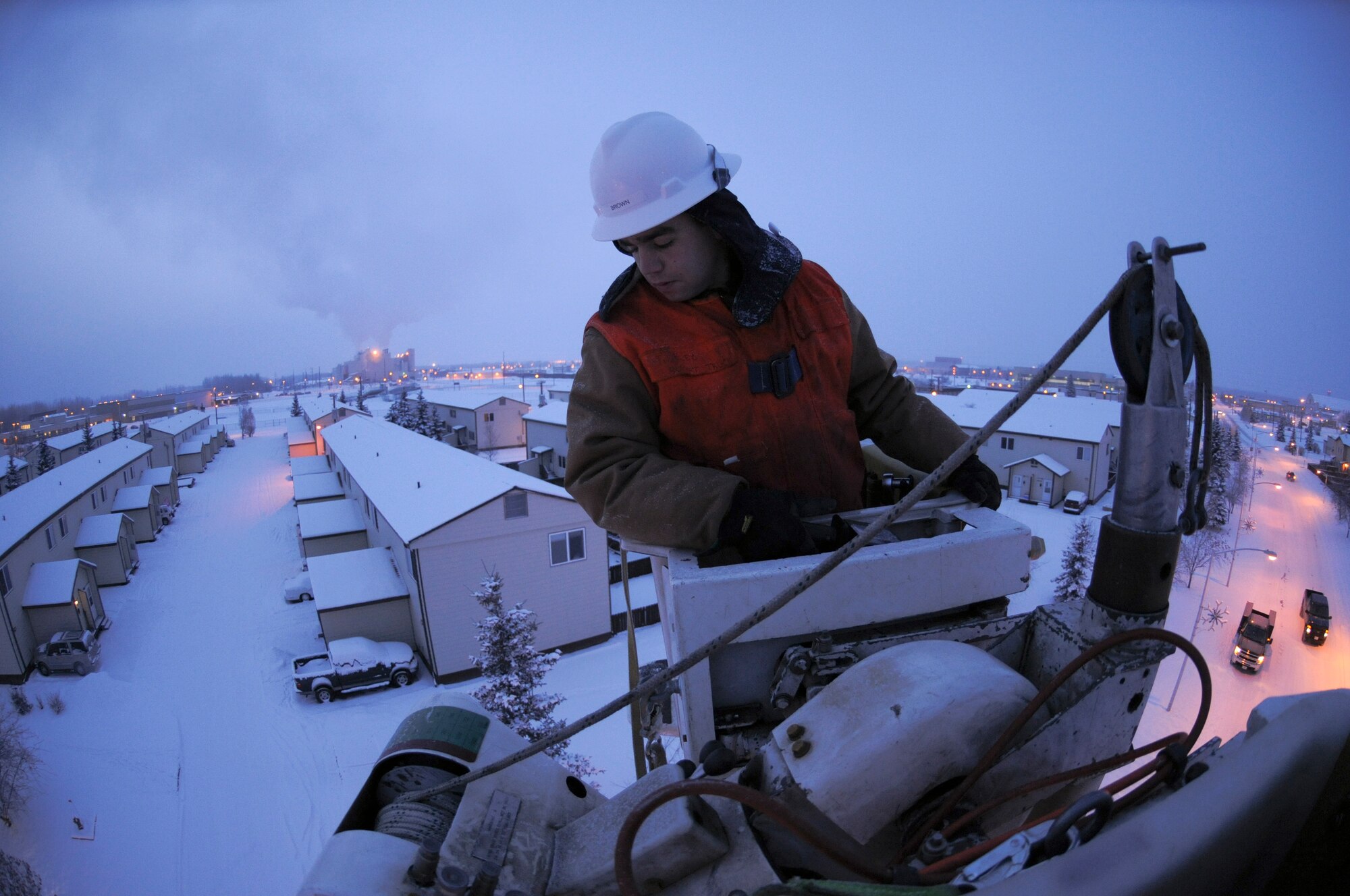 Senior Airman Scott Brown lowers the bucket of a high reach truck Feb. 2, 2009 at Eielson Air Force Base, Alaska.  The sub-zero temperature may cause the oil and hydraulics in the truck to thicken, making the lift move slower when performing maintenance on street lamps and power lines.  (U.S. Air Force photo/Airman 1st Class Laura Max) 