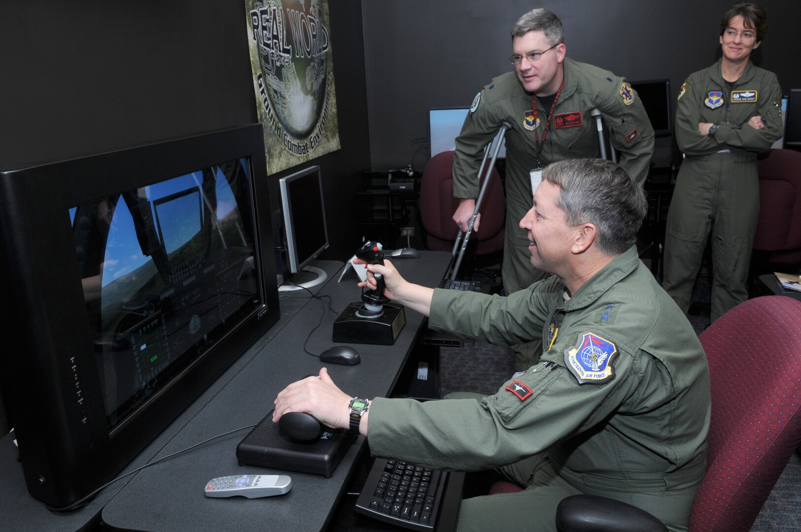 Maj. Gen. Gregory Feest, 19th Air Force commander, maneuvers himself through a simulation as Lt. Col. Chris Welborn, 563rd Flying Training Squadron commander, and Col. Jacqueline Van Ovost, 12th Flying Training Wing commander, look on. General Feest visited several areas of the 12th Flying Training Wing Jan. 29-30 to learn more about the wing and its Airmen. (U.S. Air Force photo by Joel Martinez)