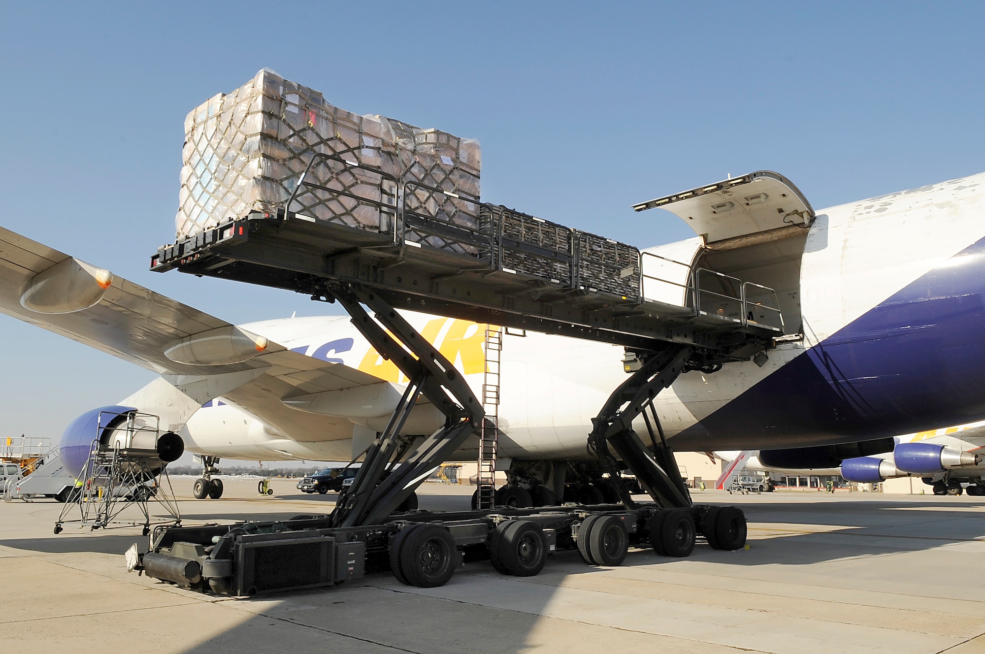 Once cargo pallets leave the 305th Aerial Port Squadron loading platforms, they are loaded onto C-17’s, KC-10's, C-5's and C-130's. In this photo, cargo pallets are being loaded onto a civilian B-747 using a K-loader. The K-loader can hold six pallets, each weighing up to 10,000 pounds, for a total weight of 60,000 pounds. The B-747 can hold 33 pallets on the upper deck and nine on the lower deck. (U.S. Air Force photo/Carlos Cintron)
