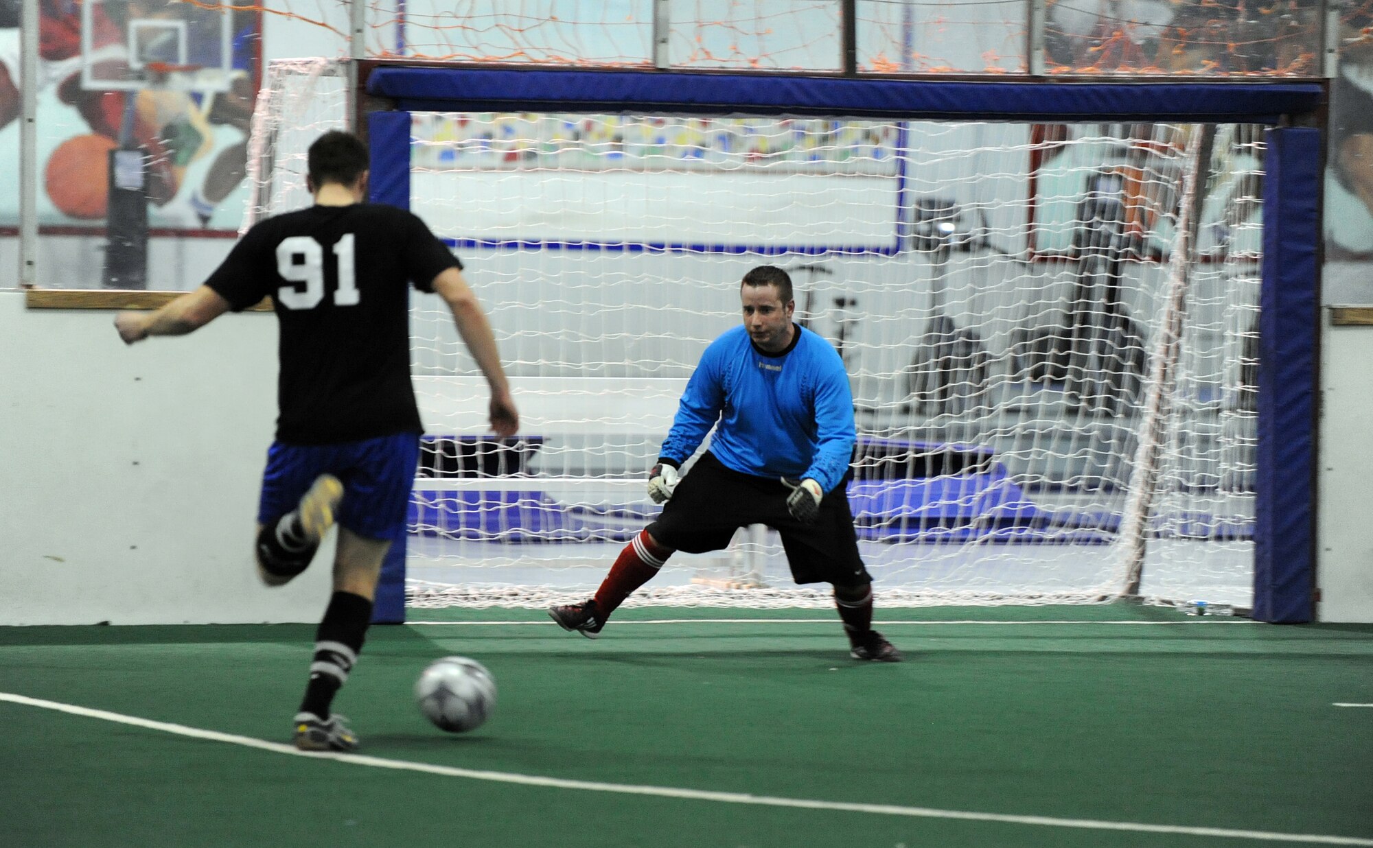 OFFUTT AIR FORCE BASE, Neb. -- Andrew Smith, U.S. Strategic Command, takes a shot on goal as goalkeeper Thomas Mooney, 55th Communications Group, prepares to make a save during the intramural soccer championship game held at the Offutt Field House, Feb. 2.  The intramural soccer league ended with  STRATCOM defeating the 55th CG 4-1.

U.S. Air Force Photo by Josh Plueger