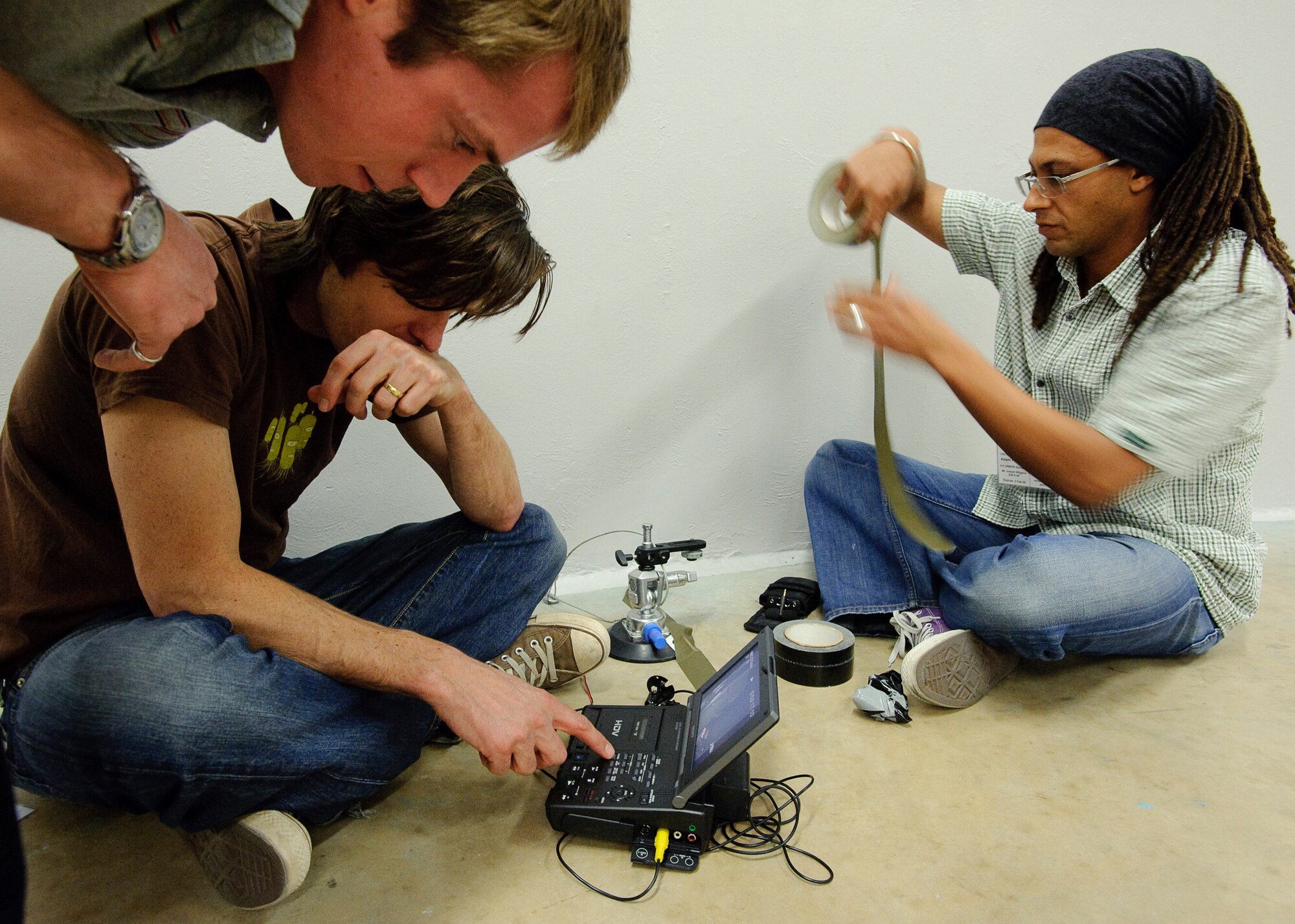 Wil Ellerby, Researcher, Tim Cragg, Camera Operator, and Adam Prescod, Sound Recordist, set up a lipstick camera and solid state audio recorder inside the Air Force Research Laboratory Centrifuge room during production of a documentary by BBC, James May on the Moon which commemorates the 40th anniversary of the Apollo 11 mission which was the first to put a man on the Moon.  James May was spun to several Gs in the AFRL Centrifuge at Brooks City-Base, TX.  His experience allowed  him to be more familiar with the experiences of Apollo 11 Astronauts Neil Armstrong, Michael Collins, and Edwin E. Aldrin, Jr., during the initial phase of launch which entered orbit of the Earth 12 minutes after takeoff.  (US Air Force photo/Steve Thurow)