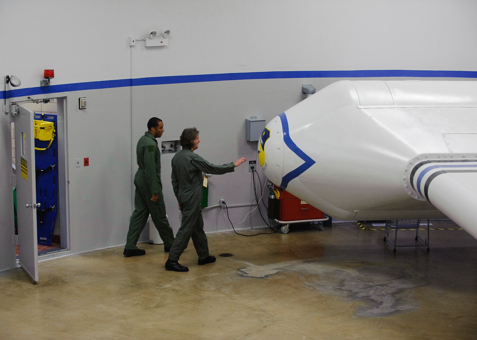 Staff Sgt. Andre Scott, Aerospace Physiology Technician with the Air Force Research Laboratory, escorts James May, Presenter with the BBC, to the AFRL Centrifuge during production of a documentary by BBC, James May on the Moon which commemorates the 40th anniversary of the Apollo 11 mission,  the first to put a man on the Moon.  May was spun to several Gs in the AFRL Centrifuge at Brooks City-Base, TX.  His experience allowed  him to be more familiar with the experiences of Apollo 11 Astronauts Neil Armstrong, Michael Collins, and Edwin E. Aldrin, Jr., during the initial phase of launch which entered orbit of the Earth 12 minutes after takeoff.  (US Air Force photo/Steve Thurow)