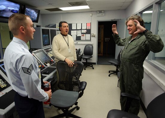 Staff Sgt. Shawn Rose an Aerospace Physiology Technician with the Air Force Research Laboratory, and Rudy Purificato, 311 Human Systems Wing Historian, react to James May as he describes the graying of his color vision during production of a documentary by BBC, James May on the Moon which commemorates the 40th anniversary of the Apollo 11 mission which was the first to put a man on the Moon. May was spun to several Gs in the AFRL Centrifuge at Brooks City-Base, TX.  His experience allowed  him to be more familiar with the experiences of Apollo 11 Astronauts Neil Armstrong, Michael Collins, and Edwin E. Aldrin, Jr., during the initial phase of launch which entered orbit of the Earth 12 minutes after takeoff.  (US Air Force photo/Steve Thurow)