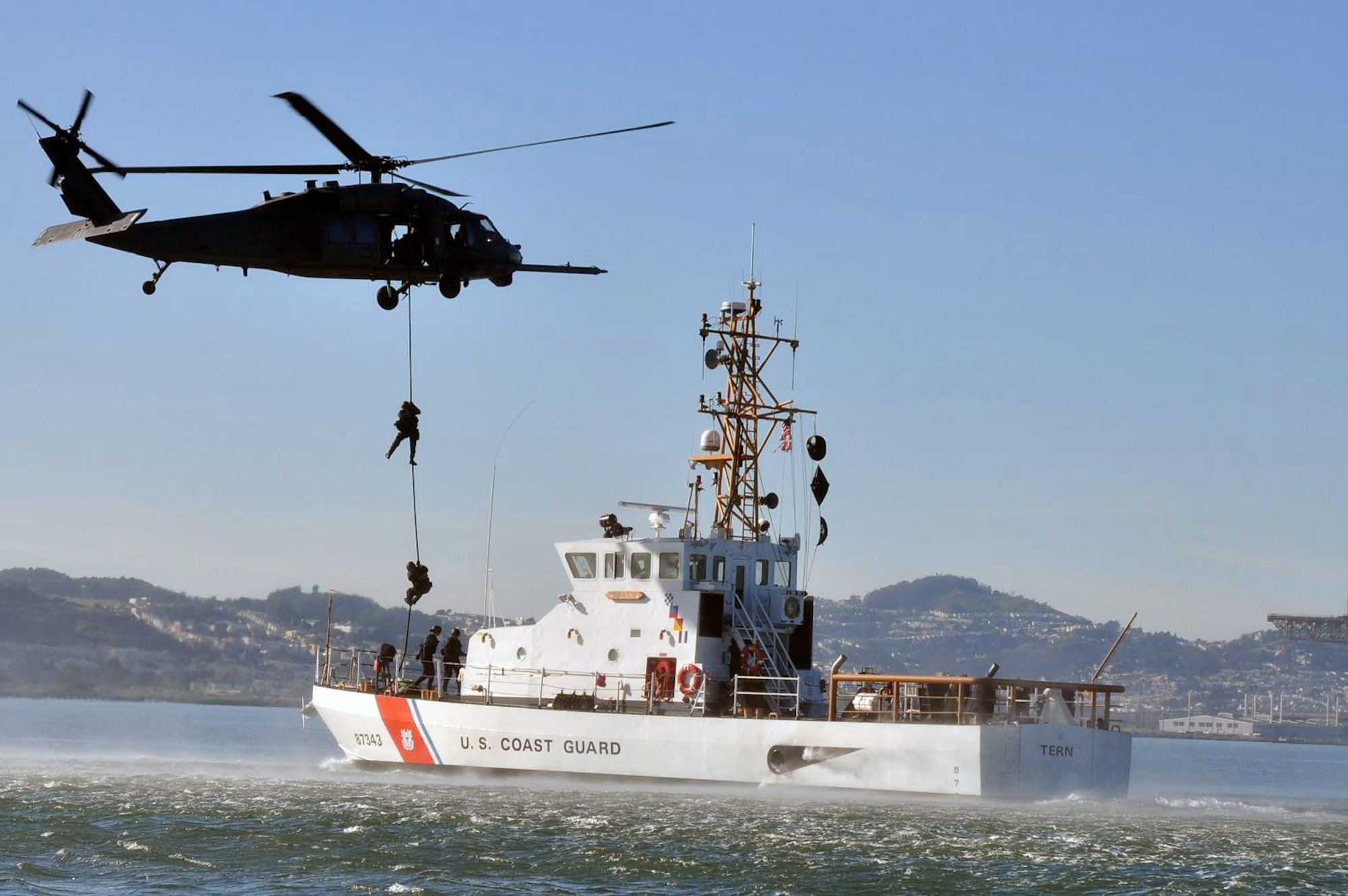 During a training exercise Jan. 29, members of the U.S. Coast Guard Maritime Safety and Security Team 91105 descend from an Air Force HH-60G Pave Hawk from the California Air National Guard's 129th Rescue Wing at Moffett Federal Airfield, Calif., onto the Coast Guard cutter Tern in the San Francisco Bay. Crewmembers conducted vertical insertion training, a fast-paced technique used to effectively deploy law enforcement teams to a high-risk situation. Shortly after the training was completed, the 129th RQW and Coast Guard crews rescued a downed pilot near Pillar Point, Calif. (U.S. Coast Guard photo/Petty Officer 3rd Class Melissa Hauck) 