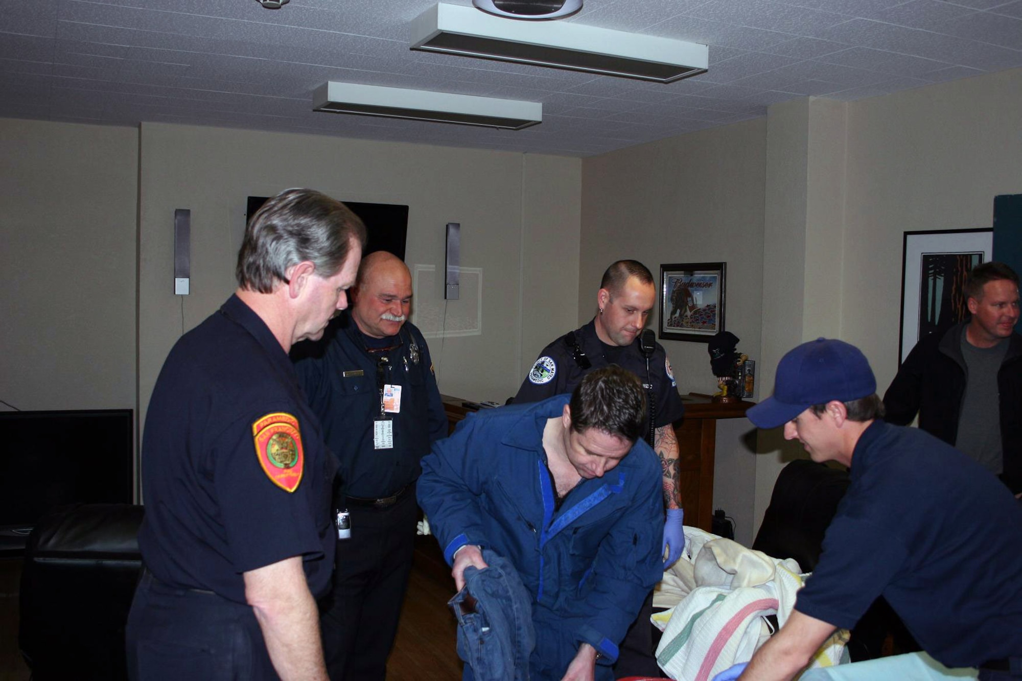 U.S. Coast Guard Air Station San Francisco personnel, emergency medical technicians and policemen from the San Francisco Police Department help the survivor of a plane crash into a survival suit Jan. 29. The survival suit was used to help raise his body temperature after the onset of hypothermia. The pilot lost power to his single-engine plane about 10 miles west of Pillar Point.  He was rescued by a California Air National Guard HH-60G Pave Hawk helicopter crew from the 129th Rescue Wing at Moffett Federal Airfield, Calif. (U.S. Coast Guard photo/Lt. j.g. Ryan Hawn) 