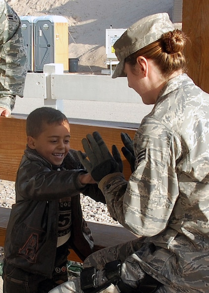 Senior Airman Tarann Earl plays with an Iraqi child while they wait for transportion to the detainee visitation center Jan. 27 at Camp Bucca, Iraq. Members of the 887th Expeditionary Security Forces Squadron provides security and transportation to the center for Iraqis who are allowed to visit daily with detained family members held at the Theater Internment Facility. Airman Earl is assigned to the 887th ESFS. (U.S. Air Force photo/Capt. Angelic Dolan) 