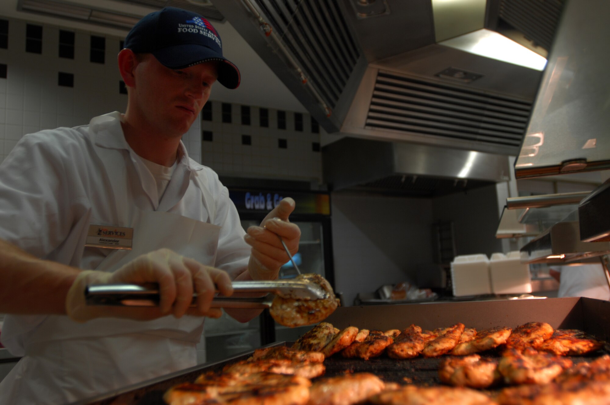 Alex Kogel, 435th Food Services contract cook, prepares chicken before the Noon lunch rush, Jan 27, 2009, at Ramstein Air Base. (U.S. Air Force photo by Airman 1st Class Kenny Holston)  