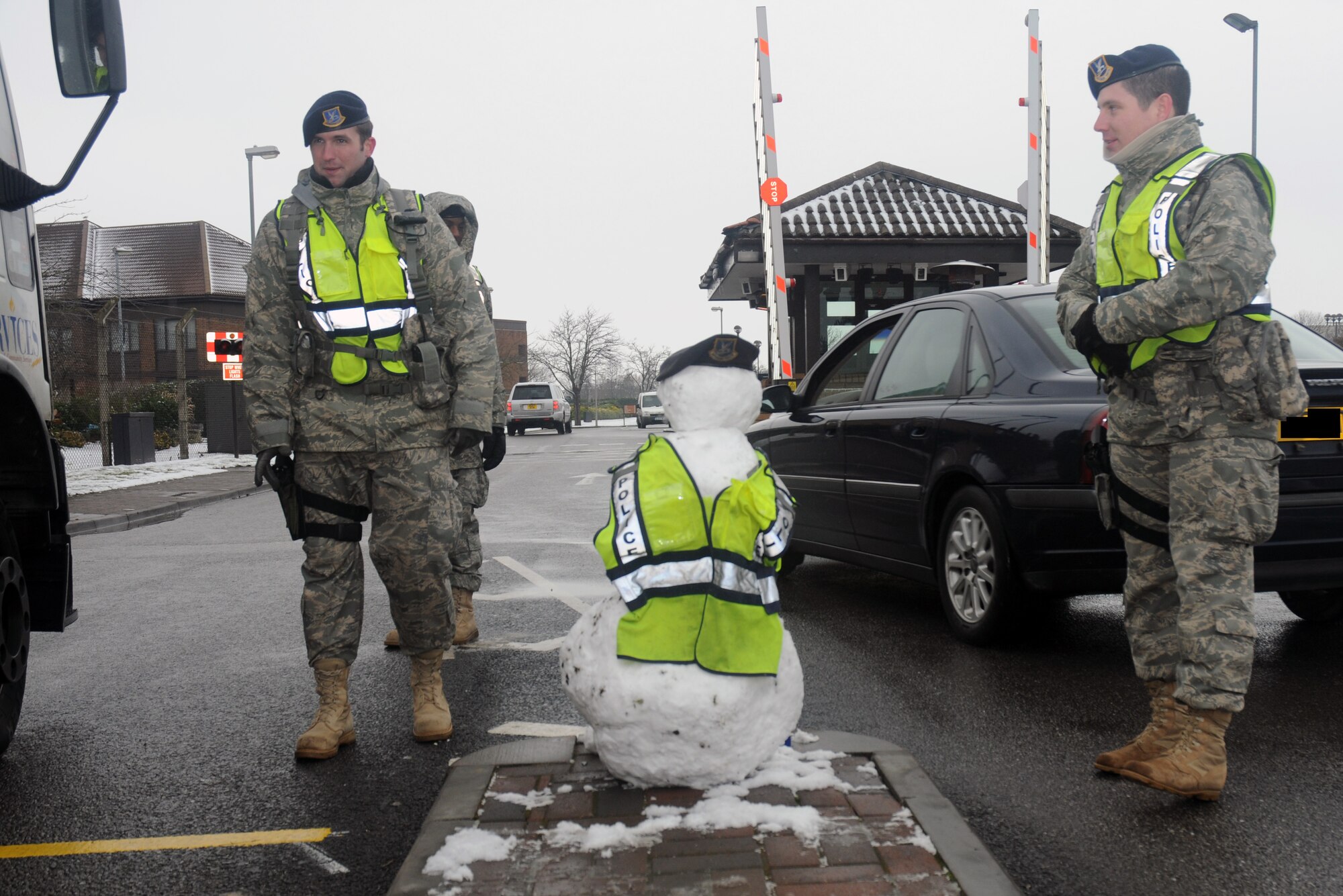 A 48th Security Forces Squadron snowman stands guard with Airman 1st Class Thomas Marshall  and Airman 1st Class  Ryan Hill at gate 1 Feb. 2 at RAF Lakenheath, England. After only arriving at Lakenheath this morning, the snowman is hard at work making sure base personnel remain safe. (U.S. Air Force photo by Senior Airman Kristopher Levasseur)