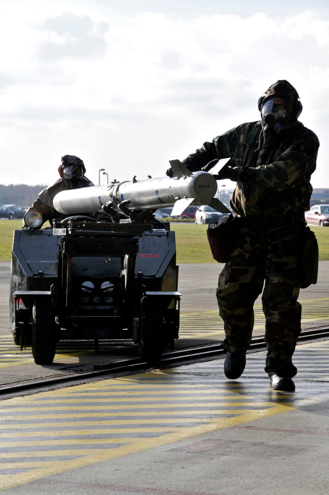 Tech Sgt. Robert Rutland, 48th Aircraft Maintenance Squadron weapons load crew team leader walks alongside the AIM-120 Missile while Airman 1st Class Eric McCain maneuvers the jammer to an F-15 Strike Eagle Jan. 27 at RAF Lakenheath, England. The weapons load crew was participating in load crews certification training which all weapons loading personnel have to accomplish before loading live and training munitions on the flightline. (U.S. Air Force photo by Airman 1st Class Perry Aston)