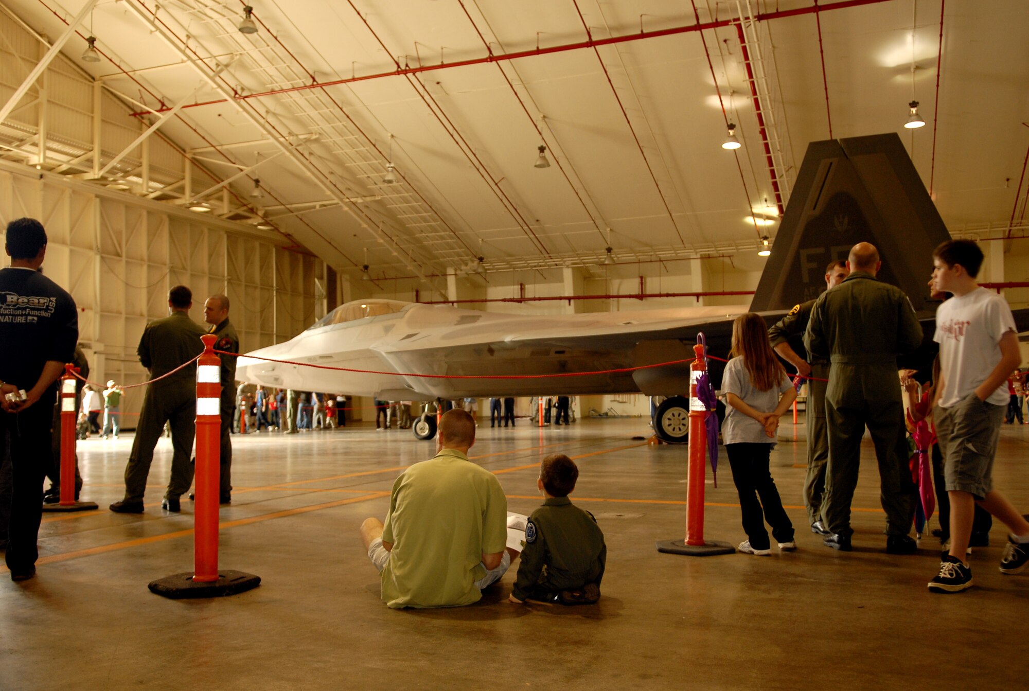 Capt. P.C. Drew and his son study the Air Force's most advanced air superiority Fighter, the F-22A, at Meet the Raptor Day, held Jan. 30, 2009 at Kadena Air Base, Japan. The 18th Wing and the 27th Expeditionary Fighter Squadron hosted the event to allow military members, Japanese employees and their families an opportunity to see the F-22A up close, talk to pilots and maintainers and learn more about the Raptors' mission in the Pacific. 12 F-22As and about 250 personnel are deployed here from Langley for a three month rotation in support of U.S. Pacific Command obligations in the western Pacific. (US Air Force photo/Junko Kinjo)