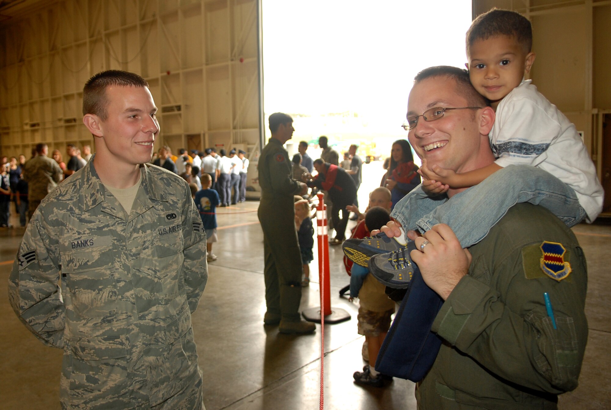 Staff Sgt. Warren G. Biles, from the 390th Intelligence Squadron, and his three-year-old son Bay Jadon Biles talk with Senior Airman Nicholas Banks, a 1st Fighter Wing crew chief from Langley Air Force Base, Va. Meet the Raptor Day was hosted by the 18th Wing and the 27th Expeditionary Fighter Squadron at the Kadena Air Base Jan. 30. (US Air Force photo/Junko Kinjo)