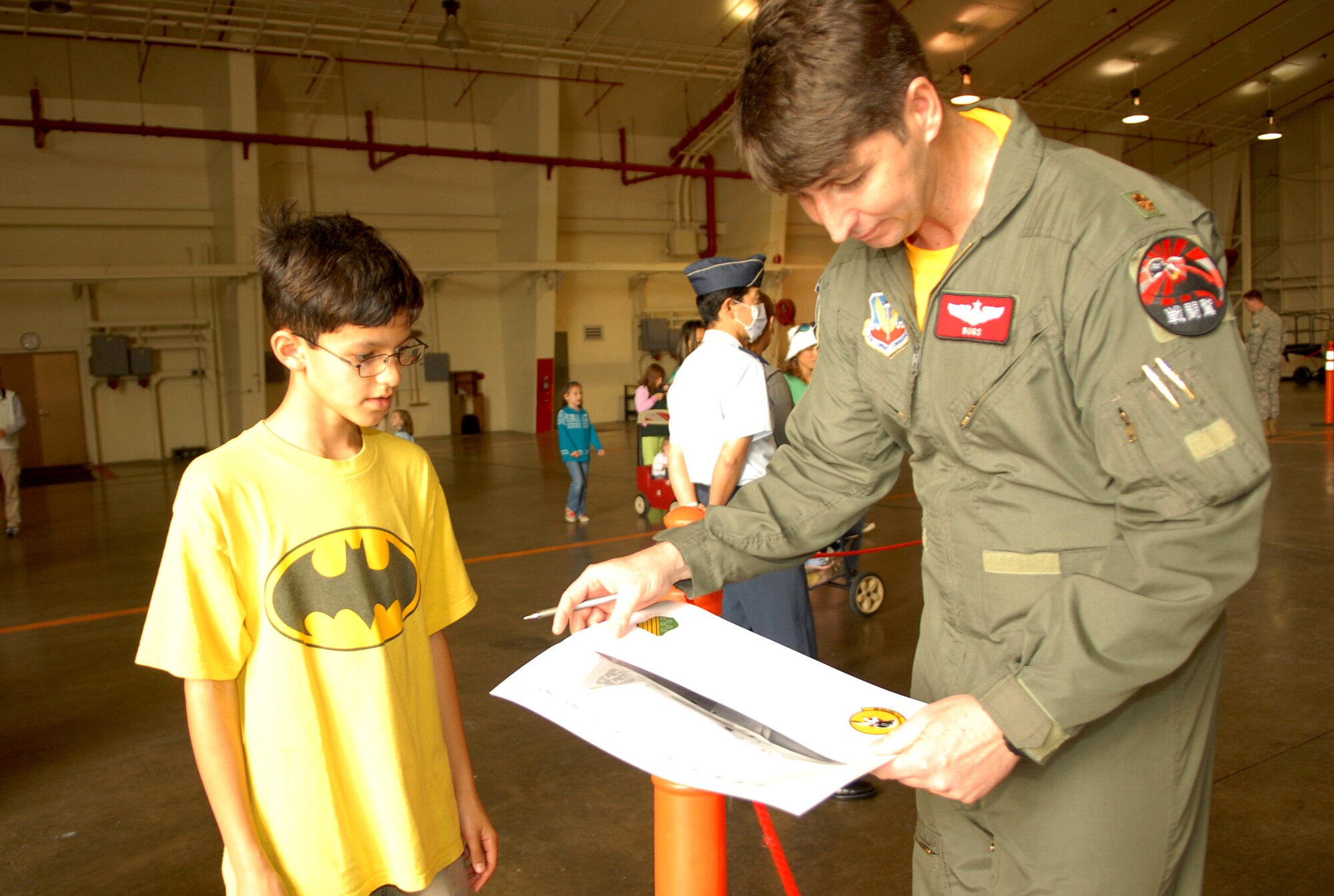 Maj. Steve Bunting, an F-22 pilot from the 149th Fighter Squadron, prepares to sign an autograph for 10-year-old Elijah Owens.  Meet the Raptor Day was hosted by the 18th Wing and the 27th Expeditionary Fighter Squadron at the Kadena Air Base Jan. 30. (US Air Force photo/Junko Kinjo)