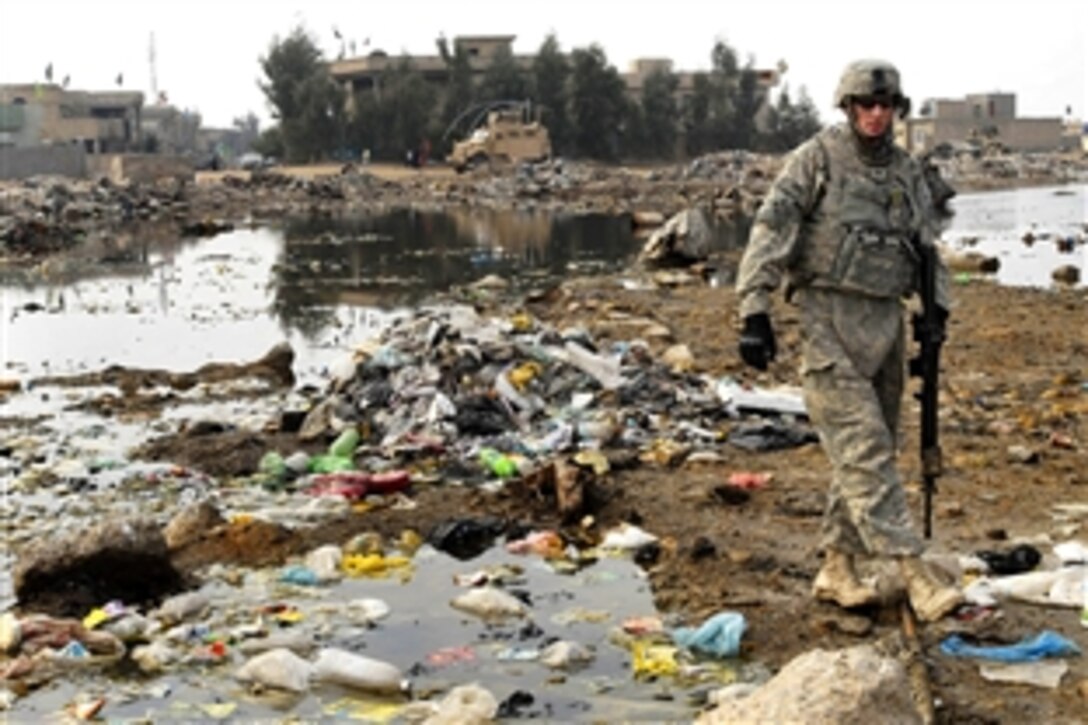 U.S. Army Spc. Cody Cornwall searches for weapons caches in debris during a dismount patrol in the Abu T'shir community of the Rashid district in southern Baghdad, Jan. 31, 2009. Cornwall is a cavalry scout assigned to the 4th Infantry Division's Troop C, 10th Cavalry Regiment, 1st Brigade Combat Team.