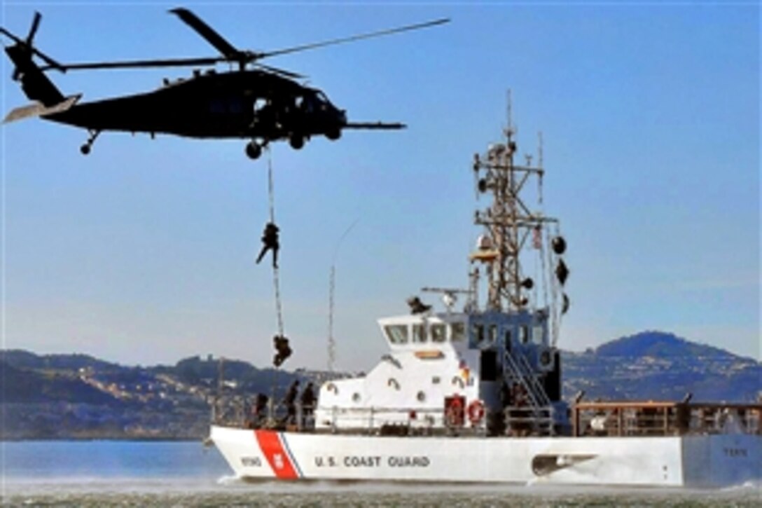 A U.S. Air Force HH-60G Pave Hawk hovers as members of the U.S. Coast Guard Maritime Safety and Security Team descend onto the Coast Guard Cutter Tern during a training exercise in San Francisco Bay, Jan. 29, 2008. The crew and helicopter are assigned to the California Air National Guard's 129th Rescue Wing on Moffett Federal Airfield, Calif.