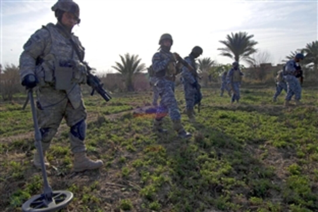 U.S. Army Spc. Steven Whipple scans a field with a mine detector to support an Iraqi police battalion while they clear potential threats in Baurga, Iraq, Jan. 30, 2009. Whipple is assigned to the 25th Infantry Division's Company B, 1st Battalion, 5th Infantry Regiment, 1st Stryker Brigade Combat Team.