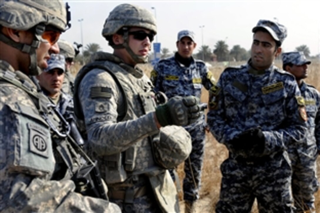 U.S. Army Staff Sgt. Matthew Arnold explains to a class of Iraqi National Police how to spot an improvised explosive device in the Doura district, Baghdad, Jan. 22, 2009. Arnold is assigned to Task Force Troy, 192nd Battalion, 752nd Explosive Ordnance Disposal Company.