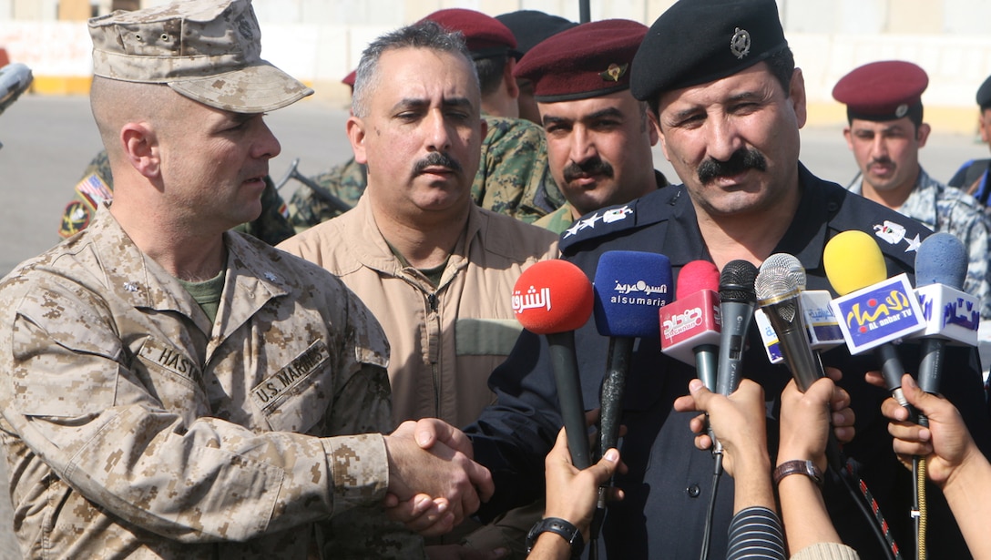 Lt. Col. Eric C. Hastings, the commanding officer of the 1st Battalion, 4th Marine Regiment, shakes hands with Col. Makhmud, Fallujah’s district Chief of Police, after signing over Entry Control Point 1 to Iraqi forces. ECP 1 was the Marine battalion’s last ECP in under their direct control. (Official Marine Corps photograph by Cpl. Ryan Turnage)