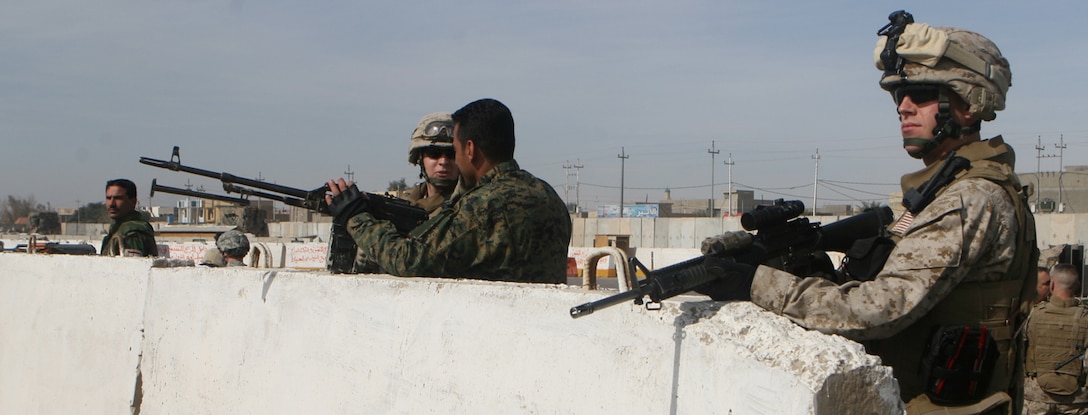 Marines with the Protective Security Detachment for 1st Battalion, 4th Marine Regiment’s commanding officer, Lt. Col. Eric C. Hastings, post security at Entry Control Point 1, along with the local Iraqi Police. The ECP was turned over to Col. Makhmud, Fallujah’s district Chief of Police. (Official Marine Corps photograph by Cpl. Ryan Turnage)