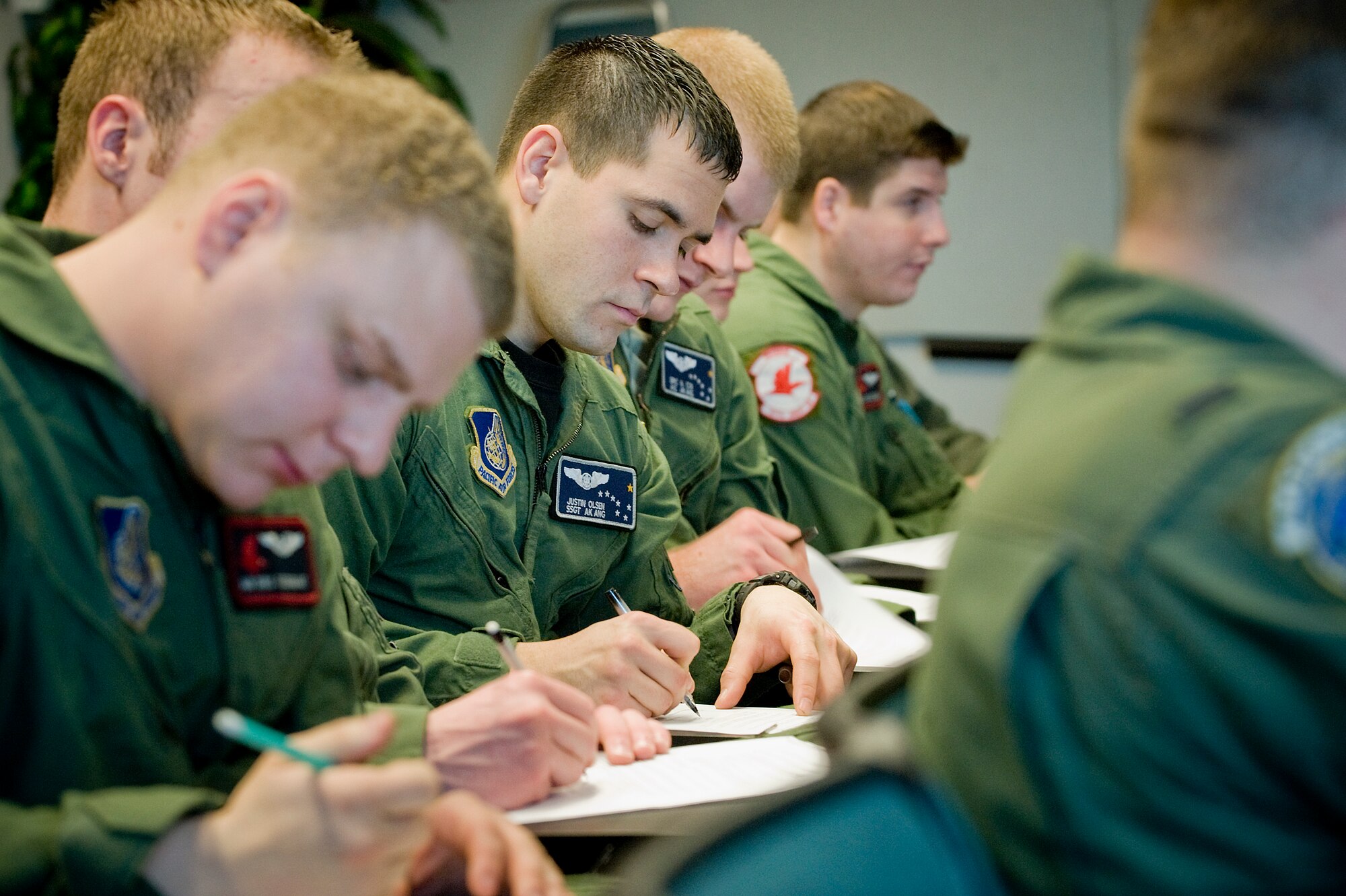Airmen from Elmendorf Air Force Base, Alaska complete paperwork during a morning briefing from Lt. Col. David Almand, 517th Airlift Squadron commander, in the 8AS auditorium here Feb. 2. (photo by Abner Guzman)