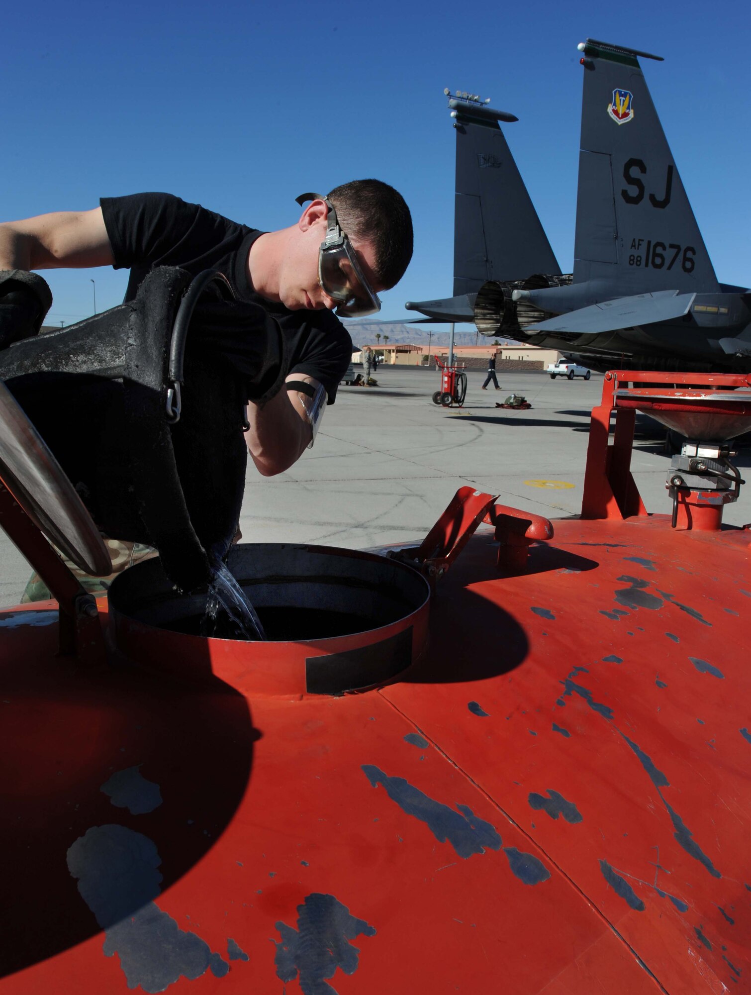 Airman 1st Class Bryant Harrison, 4 Component Maintenance Squadron at Seymour Johnson Air Force Base, N.C., removes unused JP-8 fuel from an F-15E Strike Eagle  during the Red Flag 09-2 exercise at Nellis AFB, Nev., Jan. 30. Red Flag is a multi-national exercise providing a realistic environment to practice combat scenarios. The experience gained during the exercise is vital to the survival of air crews in combat. (U.S. Air Force photo/Senior Airman Nadine Y. Barclay) 