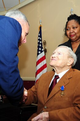 Maj. Gen. Floyd Carpenter, vice commander of 8th Air Force, shakes the hand of Mr. Walter T. Holmes after presenting him with the second-highest military award, the Distinguished Service Cross, Feb. 2. The DSC is awarded for gallentry and risk of life during combat while engaged with an armed enemy force, the gallentry must be of such a high degree that it is too high for any other military honor, but does not meet the criteria for the Medal of Honor. This award is being presented 65-years after Holmes and his fellow B-24 pilots performed low level bombing missions over the Ploesti Oil Refineries in Rumania during World War II. Most of the pilots who flew that mission were awarded the Distinguished Service Cross, while Holmes was given a Silver Star. After review by the Air Force Board for Correction of Military Records his Silver Star was upgraded two days prior to his 90th birthday. (U.S. Air Force photo by Senior Airman Joanna M. Kresge)