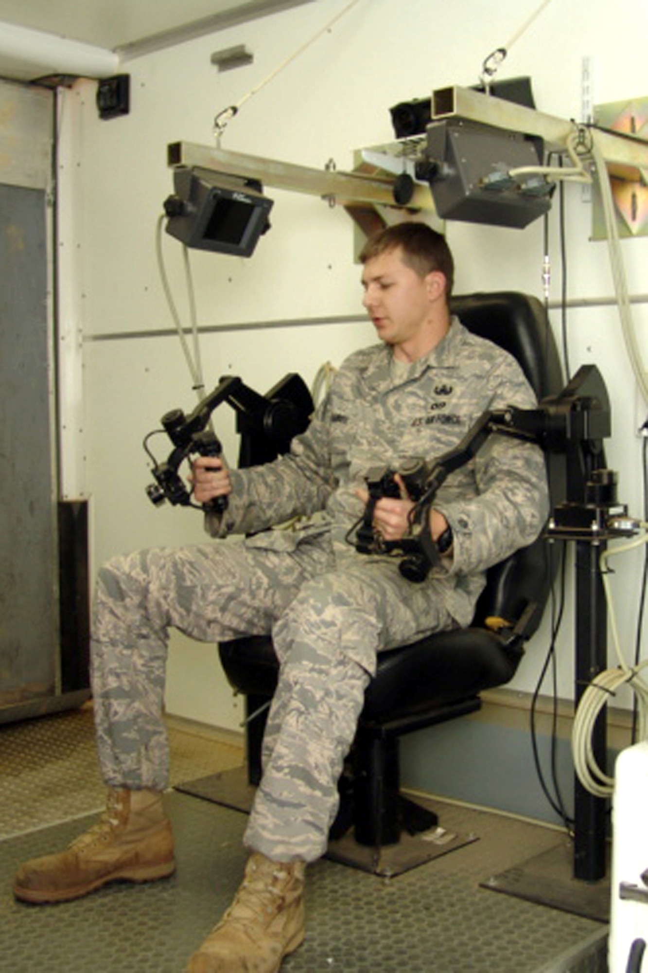 EGLIN AIR FORCE BASE, Fla. Senior Airman Brandon Harrell, EOD technician, demonstrates how to manipulate the double articulated arms attachment from inside a control trailer. The attachment is used on the All Purpose Remote Transportation System robot to retrieve bomb components from tests. 