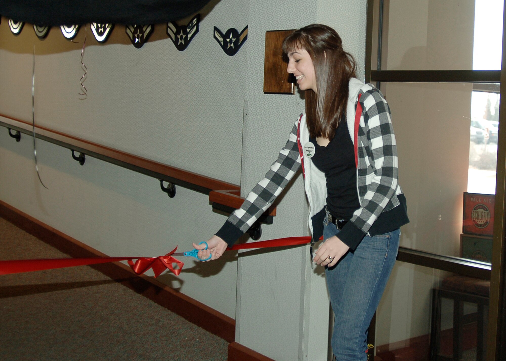 MCCONNELL AIR FORCE BASE, Kan. -- Senior Airman Felicia Butler, 22nd Mission Support Group, cuts the ribbon celebrating the opening of the Storm Cellar, Feb. 1. (Photo by Airman 1st Class Maria Ruiz)
