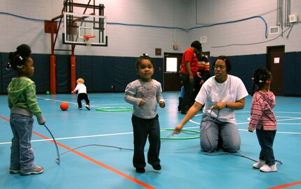 Lyvonnia Hyche teaches children how to jump rope in the Youth Programs Center gym Feb. 3. Once a week, providers get together at the Youth Programs gym for indoor play. Mrs. Hyche is a family child care provider. (U.S. Air Force photo/Airman Ian Hoachlander)