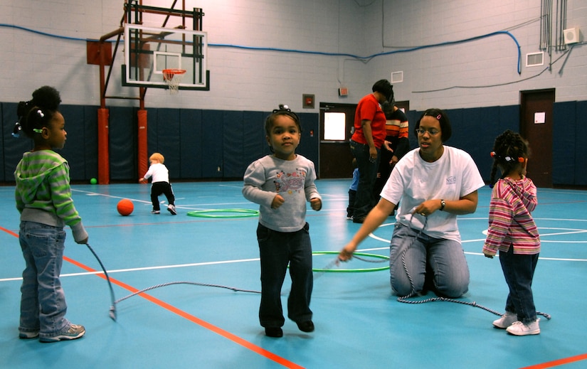 Lyvonnia Hyche teaches children how to jump rope in the Youth Programs Center gym Feb. 3. Once a week, providers get together at the Youth Programs gym for indoor play. Mrs. Hyche is a family child care provider. (U.S. Air Force photo/Airman Ian Hoachlander)