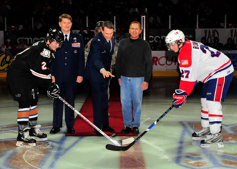 SPOKANE, Wash. –Col. Robert Thomas, 92nd Air Refueling Wing commander Fairchild Air Force Base, and Jamie Ripplinger, Representative from Coca Cola, look on as Col. Gregory Bulkley, 141st Air Refueling Wing Air National Guard commander Fairchild Air Force Base, drops the ceremonial first puck to begin the game between the Spokane Chiefs and Kooteney Ice from British Columbia, Canada, at the Spokane Arena Jan. 31. The Chiefs won the game 6-0 and took home the Championship Cup. (U.S. Air Force photo / Airman 1st Class Melissa L. Barnett)