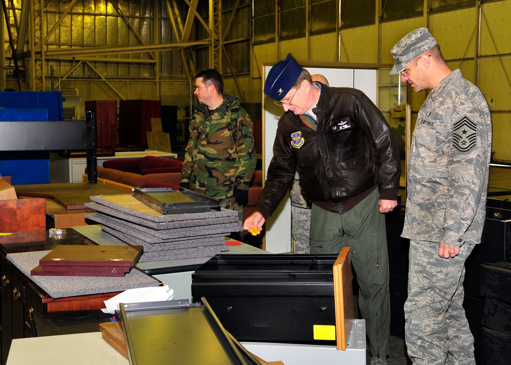 Col. Robert Thomas, 92nd Air Refueling Wing commander, and Chief Master Sgt. David Nordel, 92nd ARW command chief, walk through 23,000 lbs of old desks, filing cabinets, and couches collected during the first day of 6S at Hangar 1023 Feb. 3. 6S stands for Sort, Straighten, Shine, Standardize, Sustain and Safety. It is an Air Force Smart Operations for the 21st Century tool to help get people organized which make tasks run more smoothly and efficiently, removing unused furniture and clutter, minimizing safety hazards. More than 20 volunteers from different squadrons took part in this “spring cleaning” event. (U.S. Air Force photo / Airman 1st Class Melissa L. Barnett)