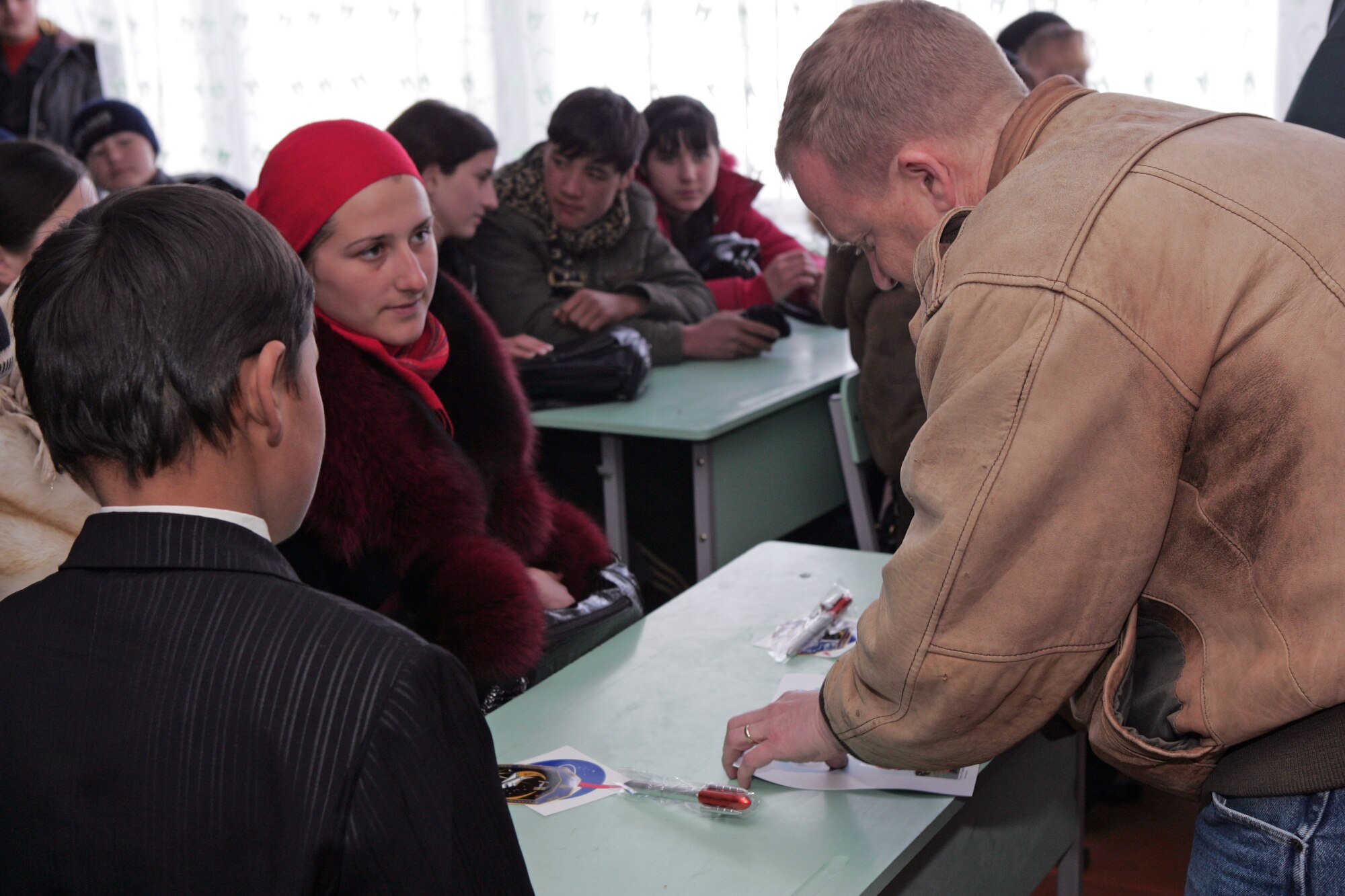 Col. Eric Boe autographs a picture for a student at the Jany-Pakhta village school in Kyrgyzstan Jan. 29 near Manas Air Base, Kyrgyzstan . Six crewmembers of the Space Shuttle Endeavour mission, which launched from Kennedy Space Center in Florida Nov. 14 and returned Nov. 30, 2008, visited the school during a tour of deployed locations supporting Operation Enduring Freedom in Afghanistan. Colonel Boe was the pilot for the STS-126 mission. (U.S. Air Force photo/Tech. Sgt. David Jones) 
