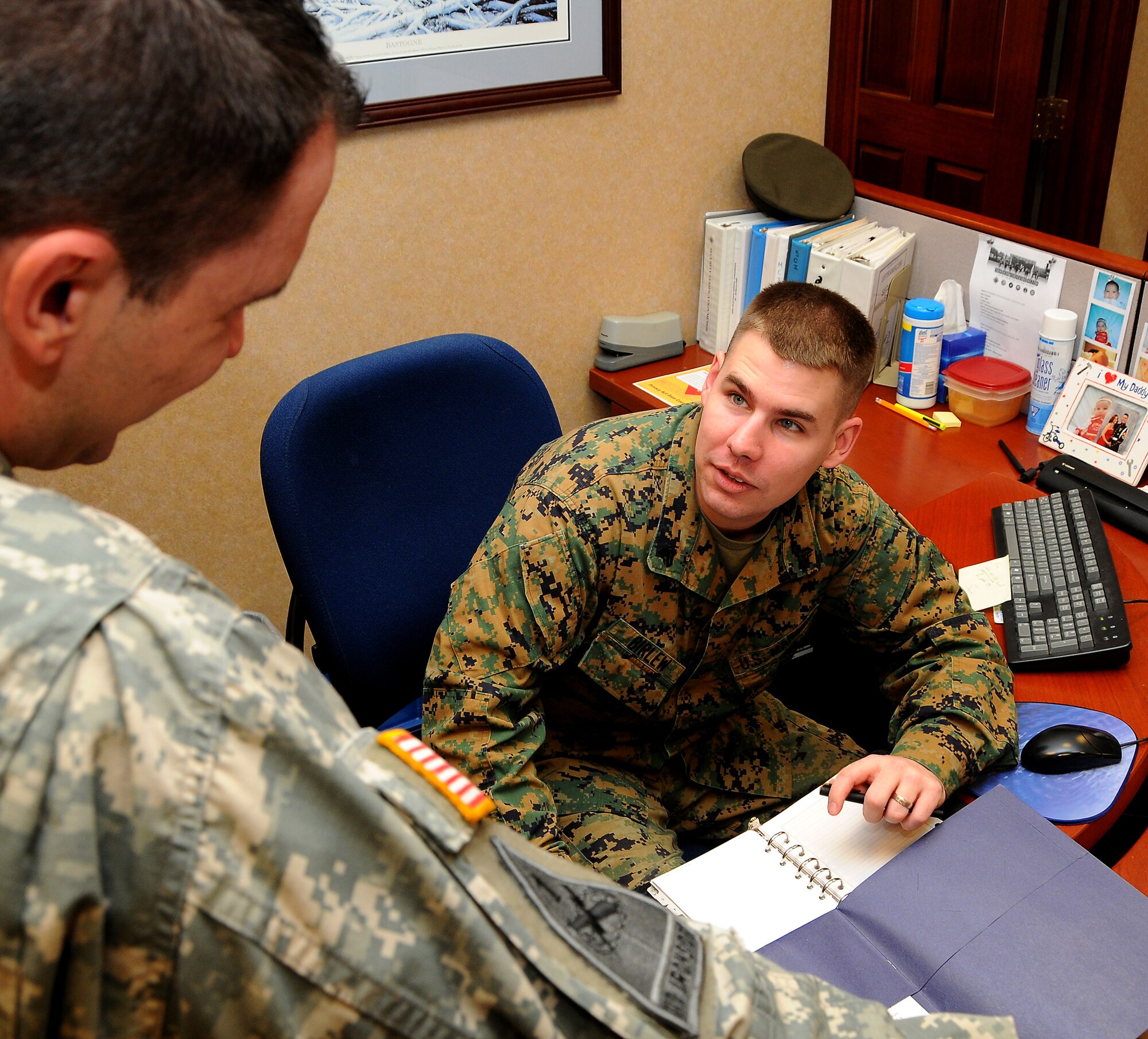 SCOTT AIR FORCE BASE, Ill. -- Marine Cpl. Timothy Birlew talks with fellow administratative assistant Army Sgt. Gregory Troxel in the U.S. Transportation Command Joint Secretariat office.  (Photo courtesy of Bob Fehringer)
