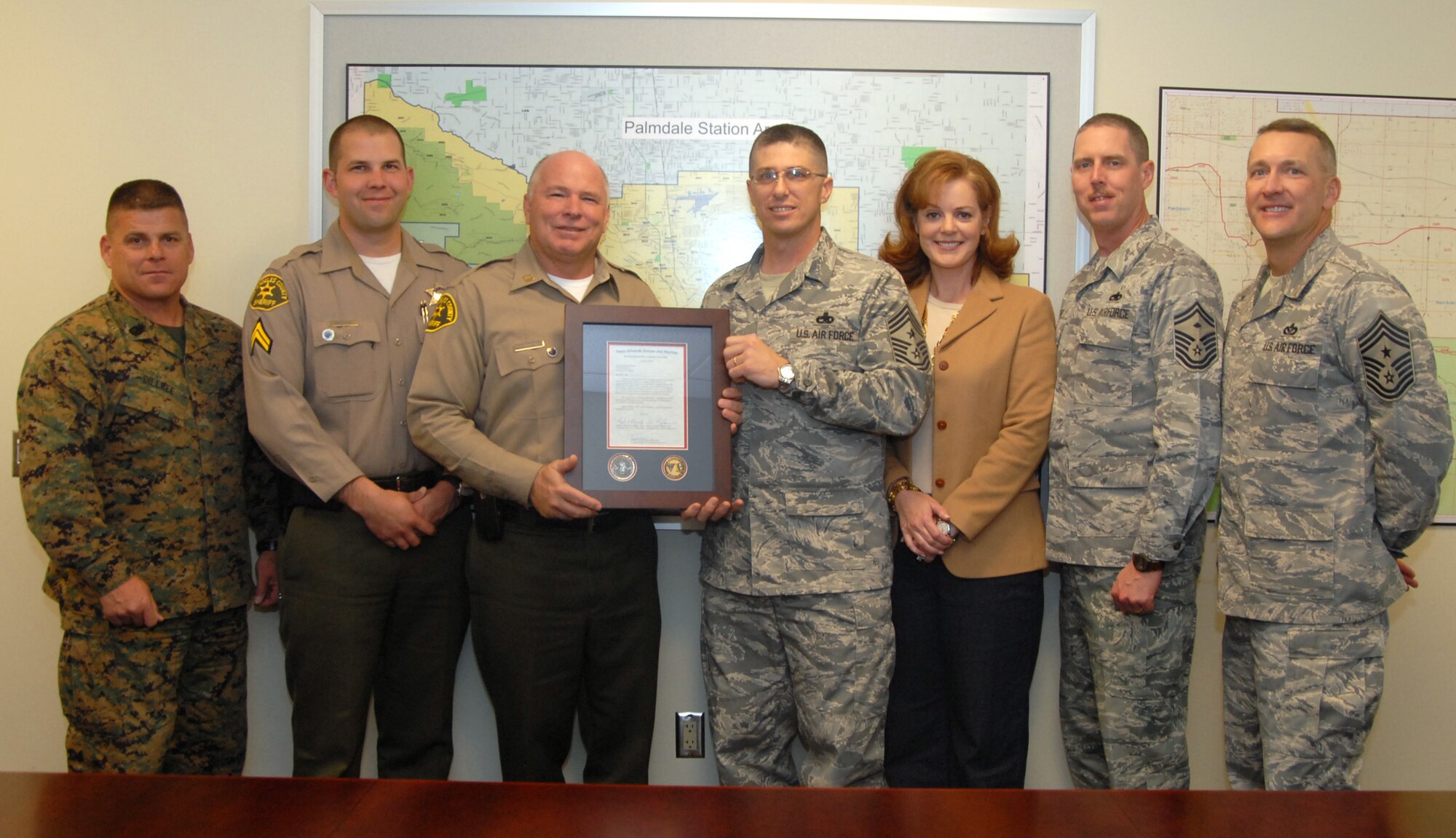 Chief Master Sgt. Eric Jaren (fourth from left), 95th Air base Wing command chief, presents a plaque of appreciation to Capt. Bobby Denham, head of the Los Angeles County Sheriff's Station in Palmdale, Calif., Jan. 28. The sheriff's station ran a toy drive to donate all toys to the Edwards community for the Angel Tree and Toys for Tots. This is part of Team Edwards' thanksgiving to local community that provided joy to military families during the holiday season.(Air Force photo by Senior Airman Julius Delos Reyes)