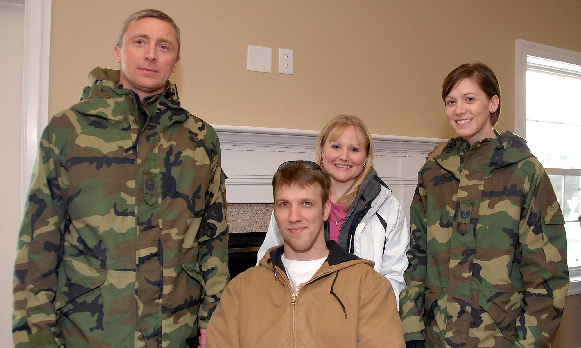 Master Sgt. Kevin Sandberg and Tech. Sgt. Jamie Eastlick,115th Fighter Wing, stand with injured Army veteran Staff Sgt. Charles Isaacson and his wife, Brenda, following a key presentation, inside a newly built Homes for Our Troops home. More than 10 Airmen from the 115 FW contributed to the home, located in Sun Prairie, during a three-day build brigade. The home features many of the special accomodations that Sergeant Isaacson needs to accomodate his injuries from the War on Terror. (U.S. Air Force Photo by Master Sgt. Dan Richardson)