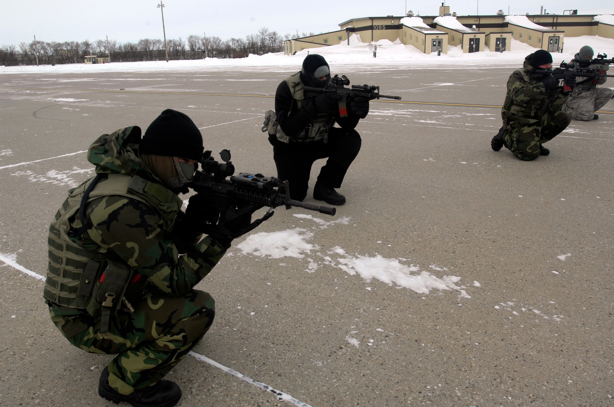 Airmen from the 5th Security Forces Squadron endure the harsh cold during the Blue Coach Training Initiative at Minot Air Force Base, N.D., Jan 8. A Navy Sea, Air and Land team is helping to train 200 Minot security forces members on recapturing and combat tactics by April. (U.S. Air Force photo/Airman 1st Class Jesse Lopez)