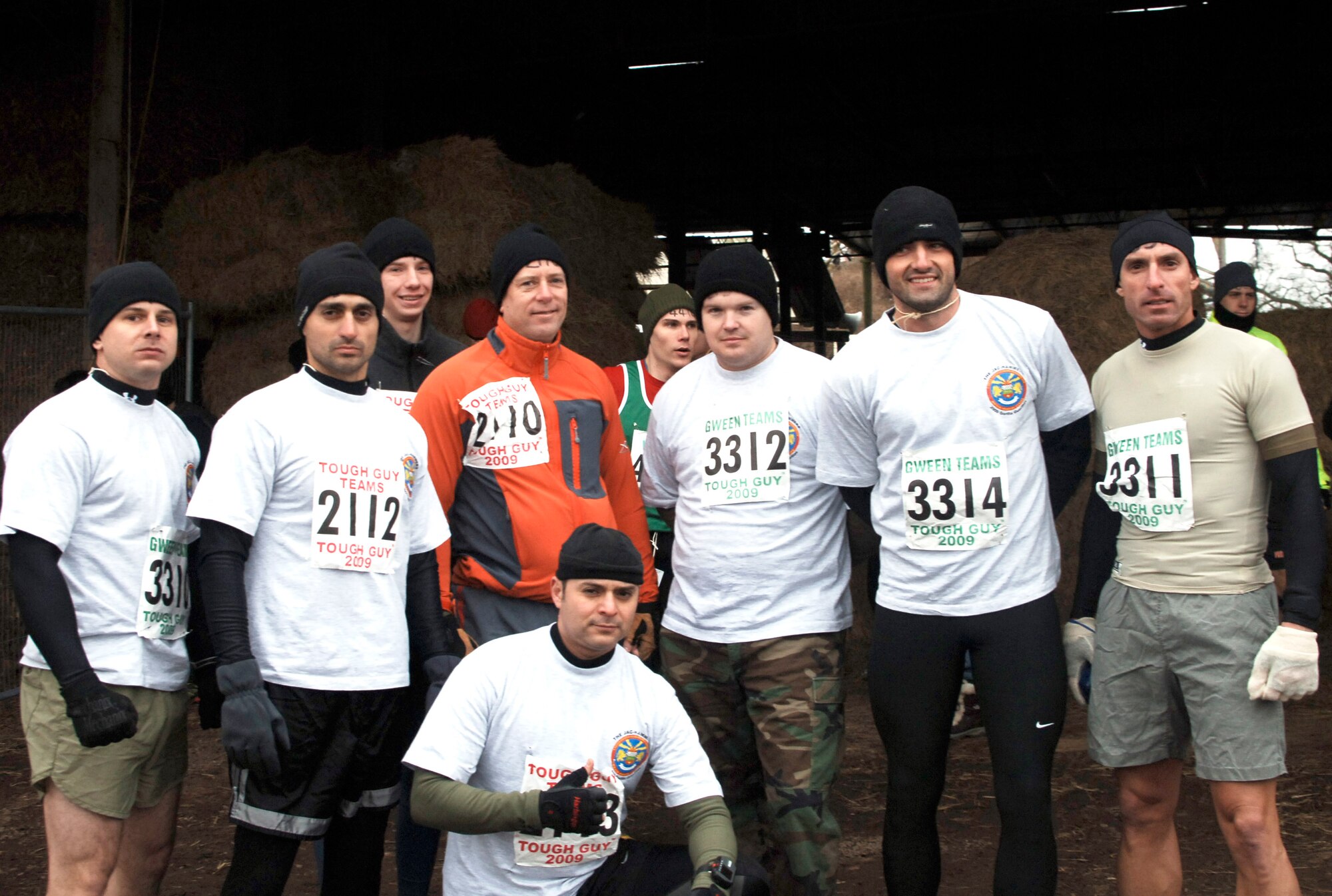 The JAC HAMMERS team for the Winter Tough Guy 2009 "The Bold and the Beautiful" poses before the start of the grueling 8 mile course of obstacles, water, mud and more mud in Perton, England.  From left to right: Marine Corps Sgt. Matt Johnson, Navy Lt, Rahaghi, Anthony Devlin, Marine Corps Col Pete Devlin, Navy Lt. Jose Lepesuastegui, (person not part of team), Air Force Staff Sgt. Chad Chisholm, Navy Lt. Adam Waltz, and Navy Lt. Daniel Avondoglio. (U.S. Air Force Photo by Staff Sgt. Rachel Goff)
